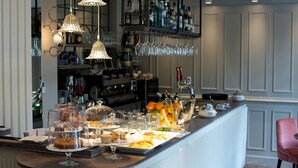 A bar area with a variety of drinks, glasses, and food items displayed on the counter. - Fuori Porta House (Bergamo)