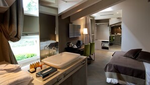 A hotel room with a bed, a bathroom with a sink, a desk, and a chair. - Fuori Porta House (Bergamo)
