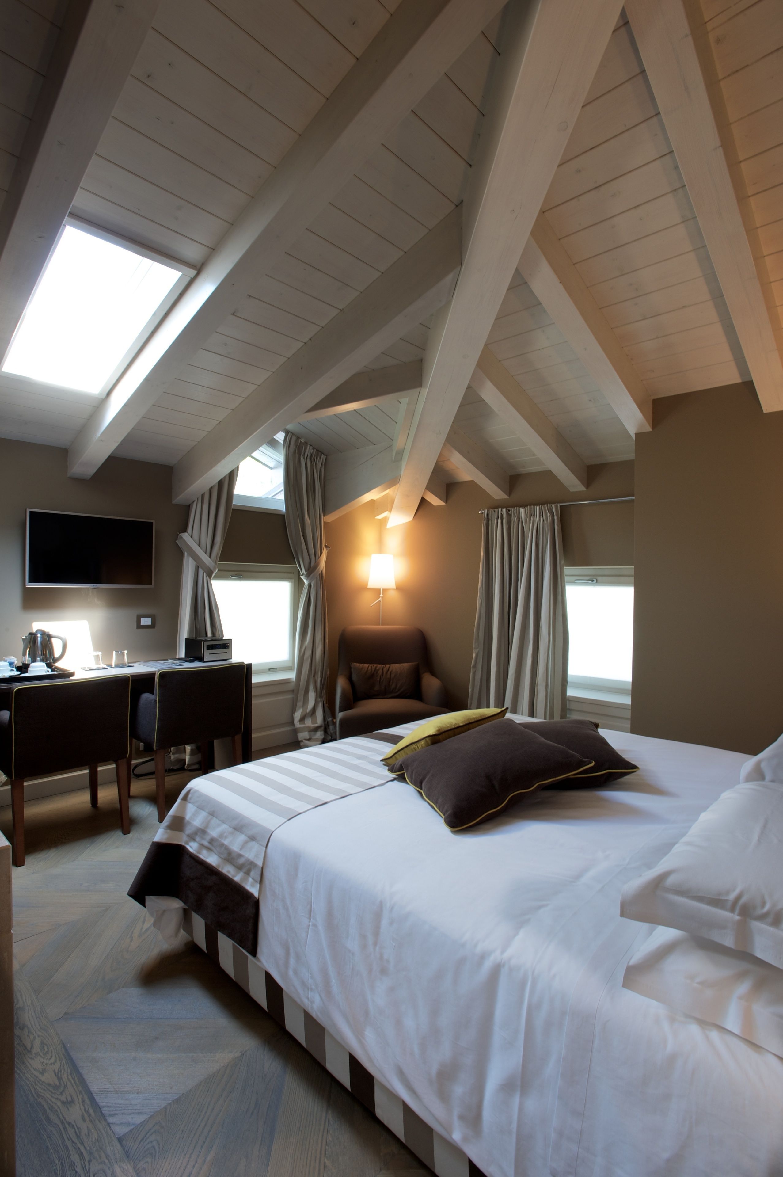 Une chambre à coucher comprenant un lit, un bureau, une chaise et un téléviseur fixé au mur.