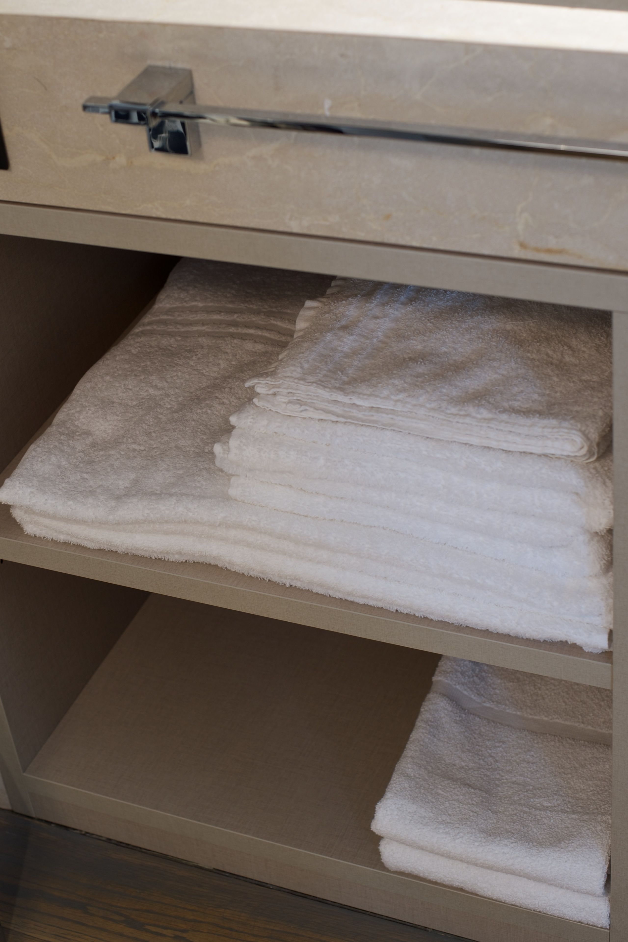 Une salle de bain avec un porte-serviettes sur lequel sont pliées des serviettes.