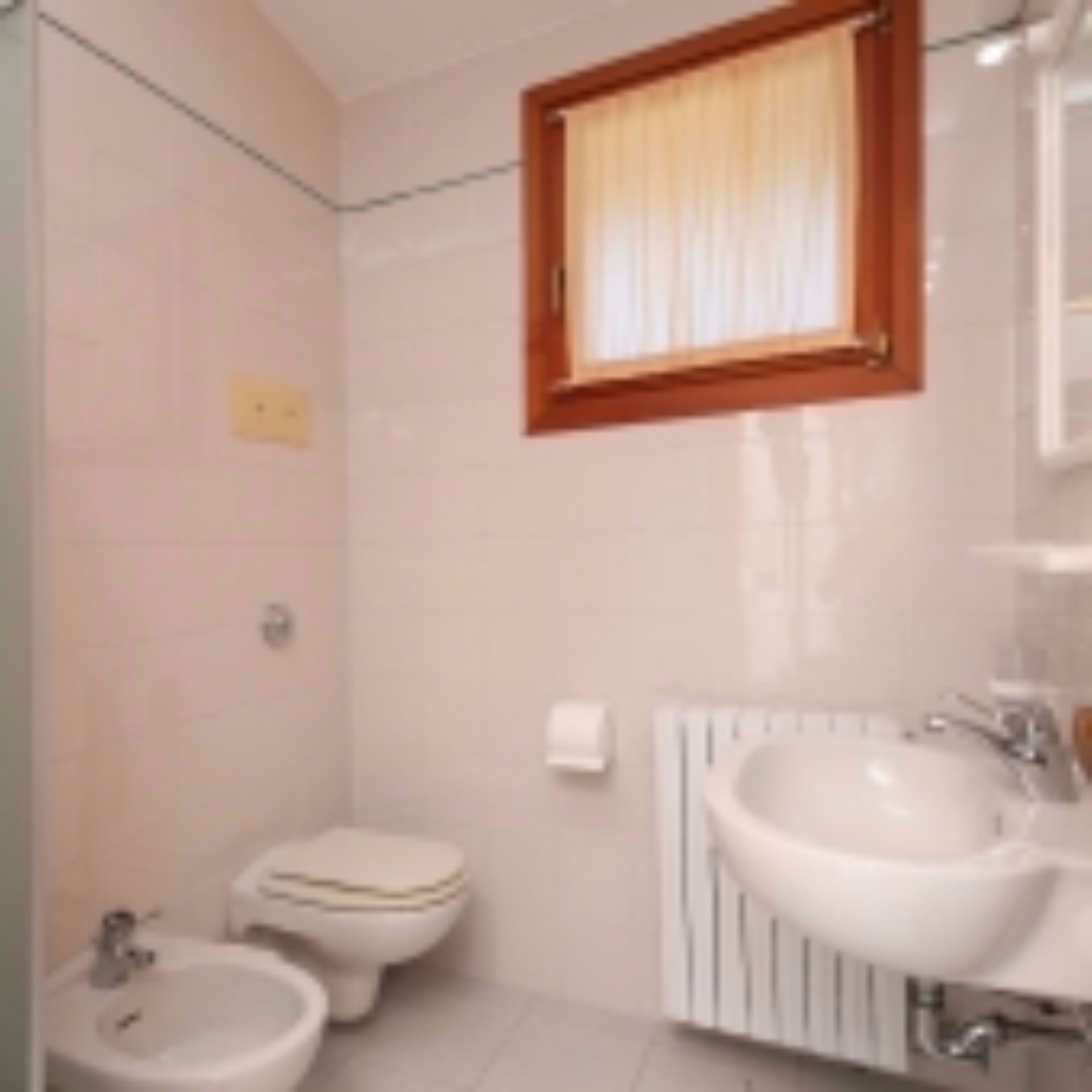 Ein Badezimmer mit Toilette, Bidet und Waschbecken.