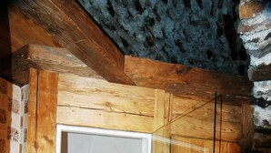 A wooden door leading to a tiled shower area with a visible drain. - Appartamenti Pellizzano (Pellizzano)