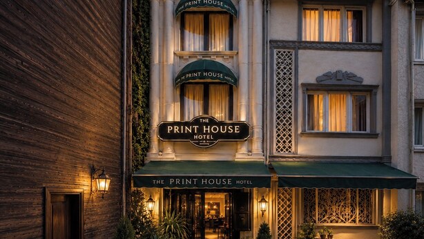 Un hôtel reconnaissable à son enseigne bien visible, « The Print House Hotel », qui se distingue par sa façade traditionnelle, ornée de nombreuses fenêtres et dotée d’une entrée accueillante.