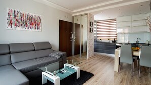 A modern living room with a grey sofa, a glass coffee table, and a black rug. - Old Town Luxury Apartments by Amstra (Kraków)