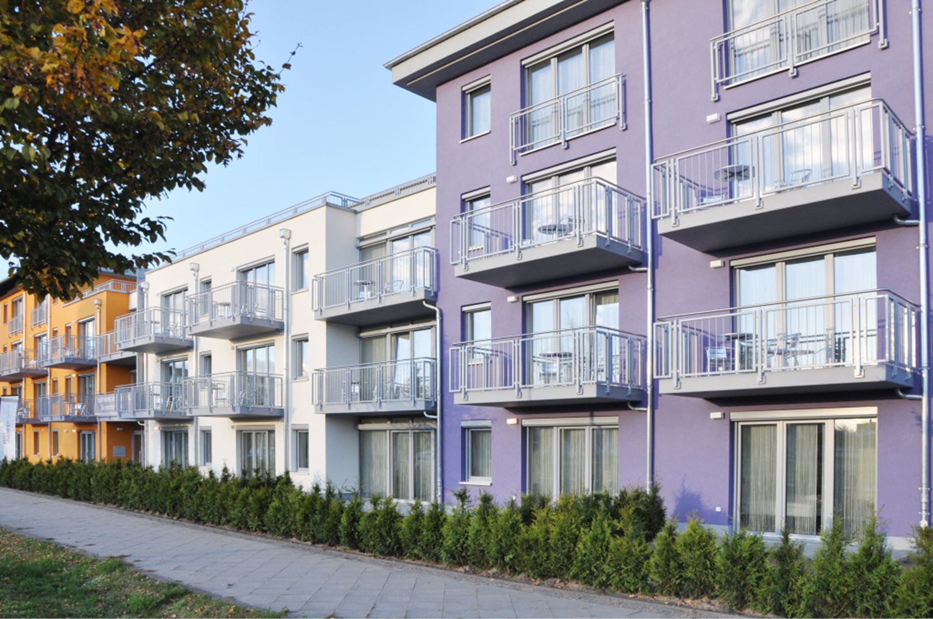 A row of modern apartment buildings with balconies and large windows.