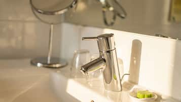 Un lavabo de salle de bain avec un robinet chromé, un miroir et un porte-savon.