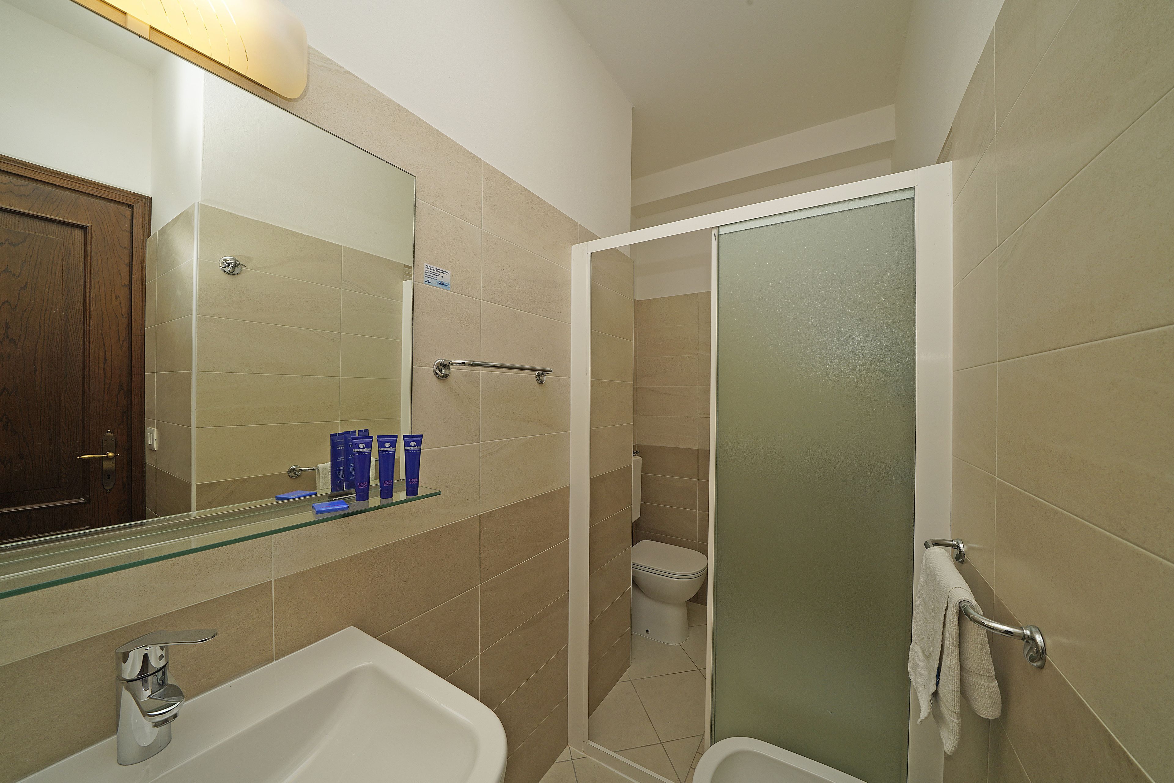 A bathroom with a bathtub, a toilet, and a shower area.