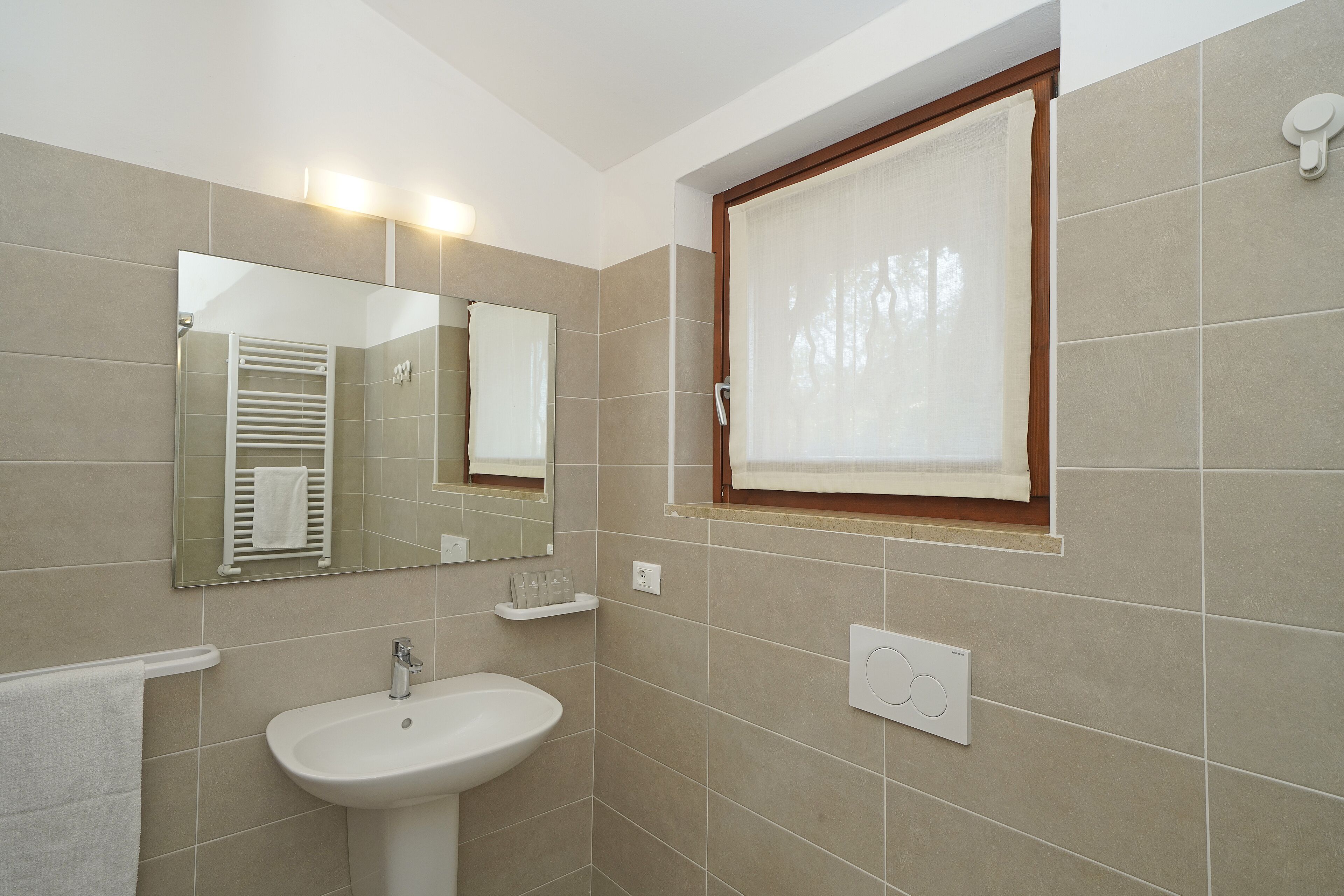 A bathroom with a sink, mirror, towel rack, and window with blinds.