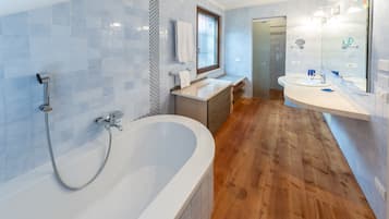 A modern bathroom with a freestanding bathtub, a vanity with a mirror, and a shower area.