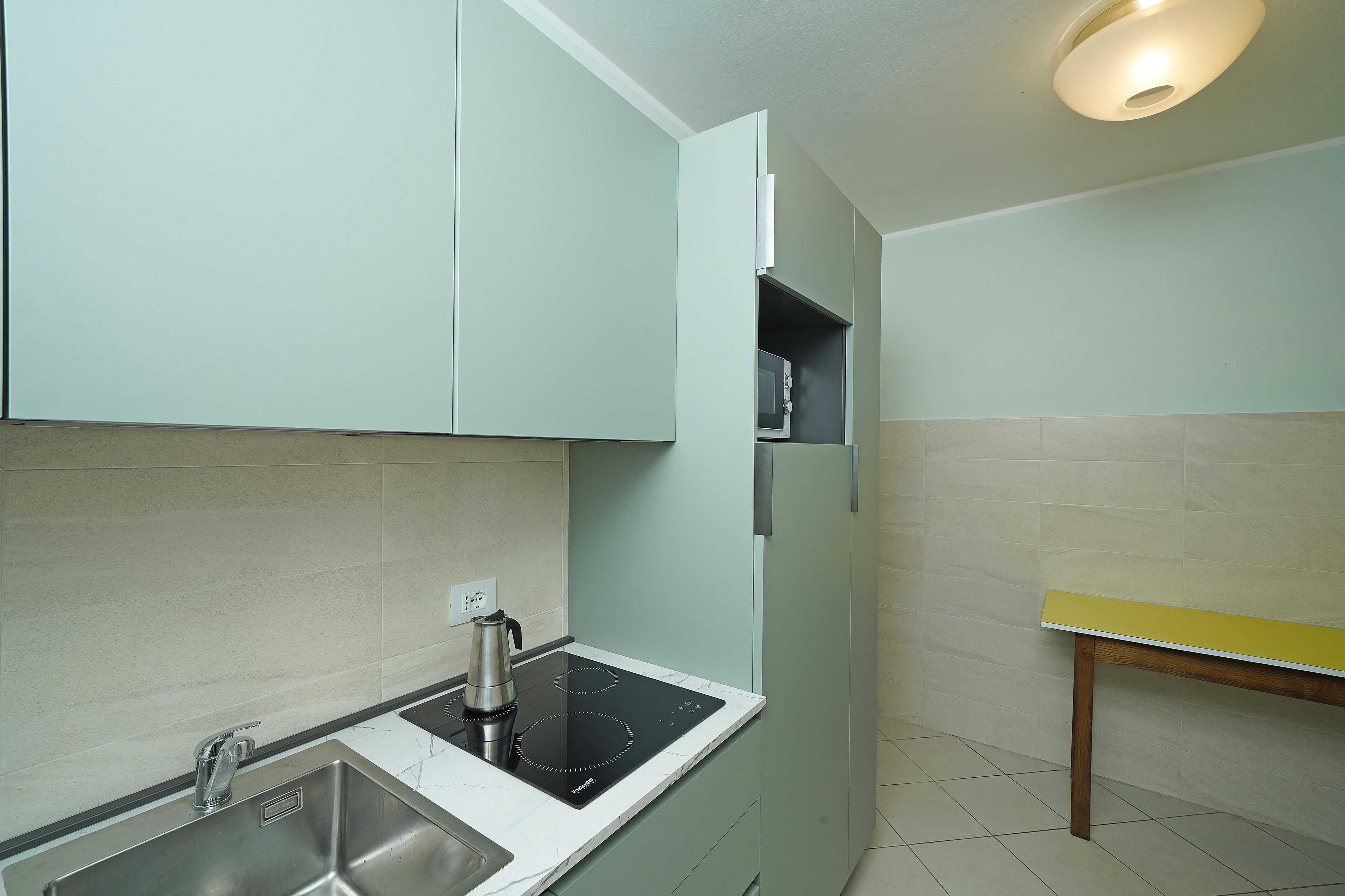 A kitchen with a sink, stove, and cabinets.