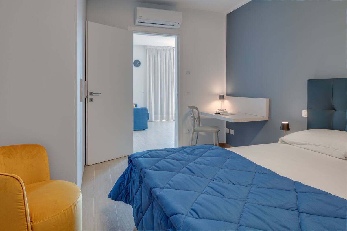 Une chambre d’hôtel équipée d’un lit, d’un bureau, d’une chaise et d’un appareil de climatisation.
