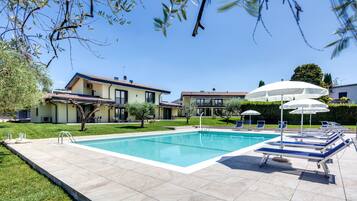 Relax by the rectangular pool surrounded by lush greenery and modern architecture.