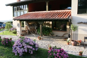 Ein Haus mit Ziegeldach, einer Veranda und Topfpflanzen.