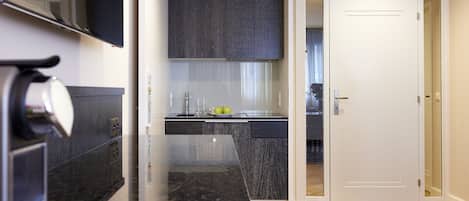 A modern kitchen with dark cabinetry, a stainless steel sink, and a wooden herringbone floor.