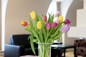 Um vaso de vidro transparente com um buquê de tulipas em várias cores.