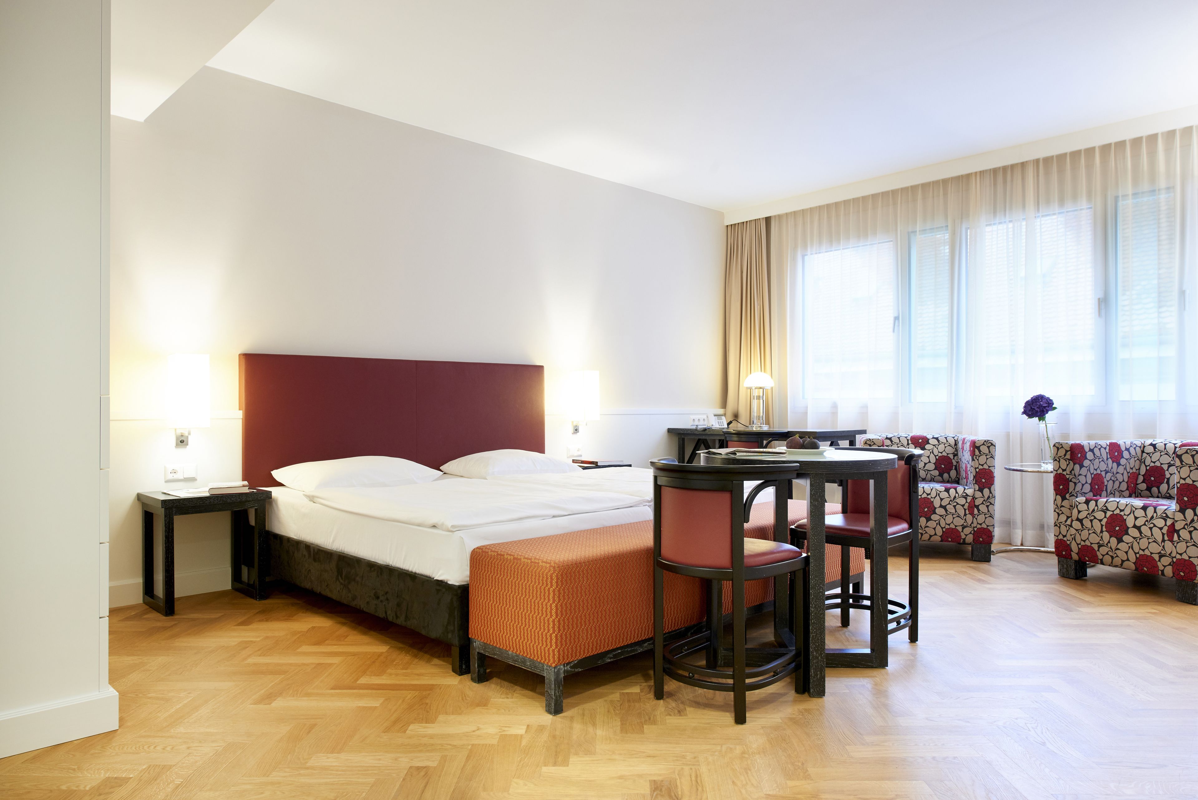 Una habitación de hotel con cama, escritorio, silla y sofá.