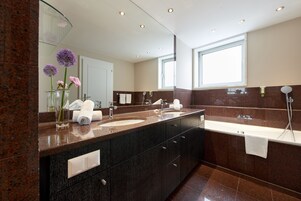 Uma casa de banho moderna com duas pias, um espelho grande e uma janela.
