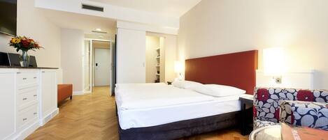 Una habitación de hotel con cama, escritorio, silla y televisión.