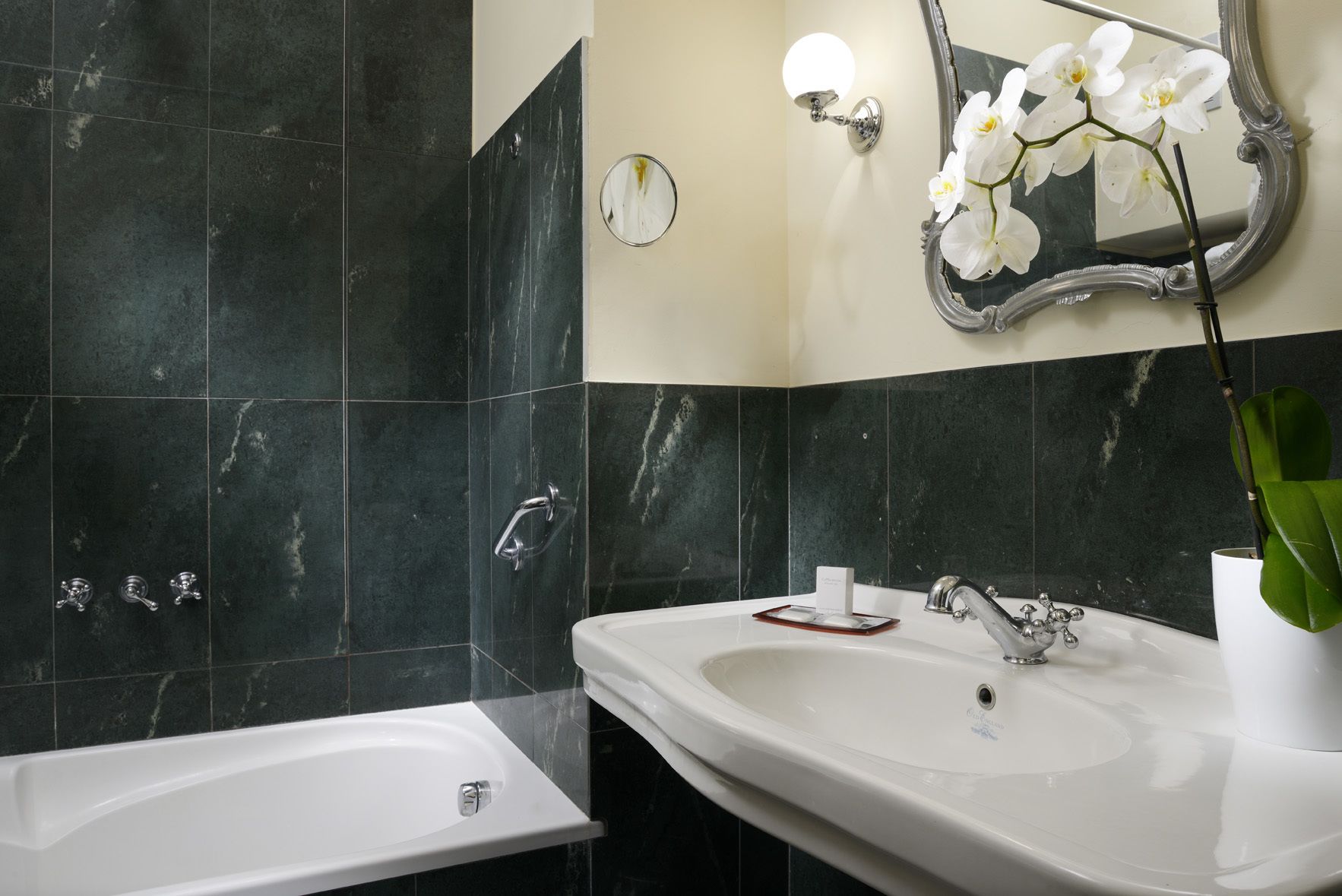 A bathroom with a bathtub, a sink, and a mirror.