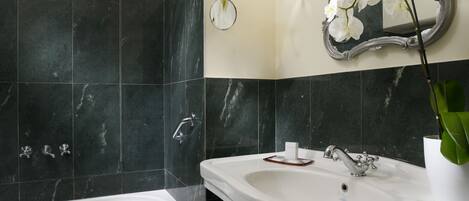 Une salle de bain avec une baignoire, un lavabo et un miroir.