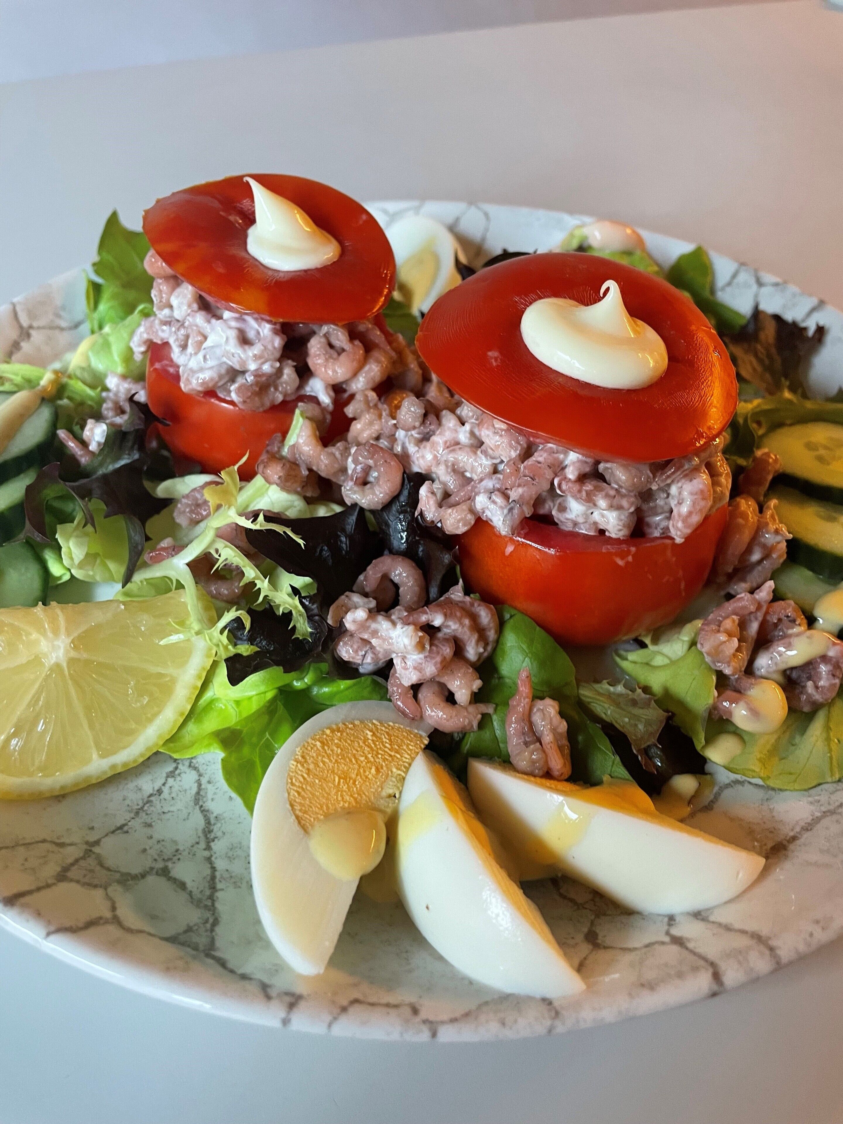A salad with tomatoes, lettuce, and other vegetables on a plate.