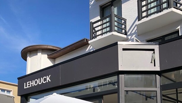 Um restaurante chamado LEHOUCK com área externa e um vaso de planta.