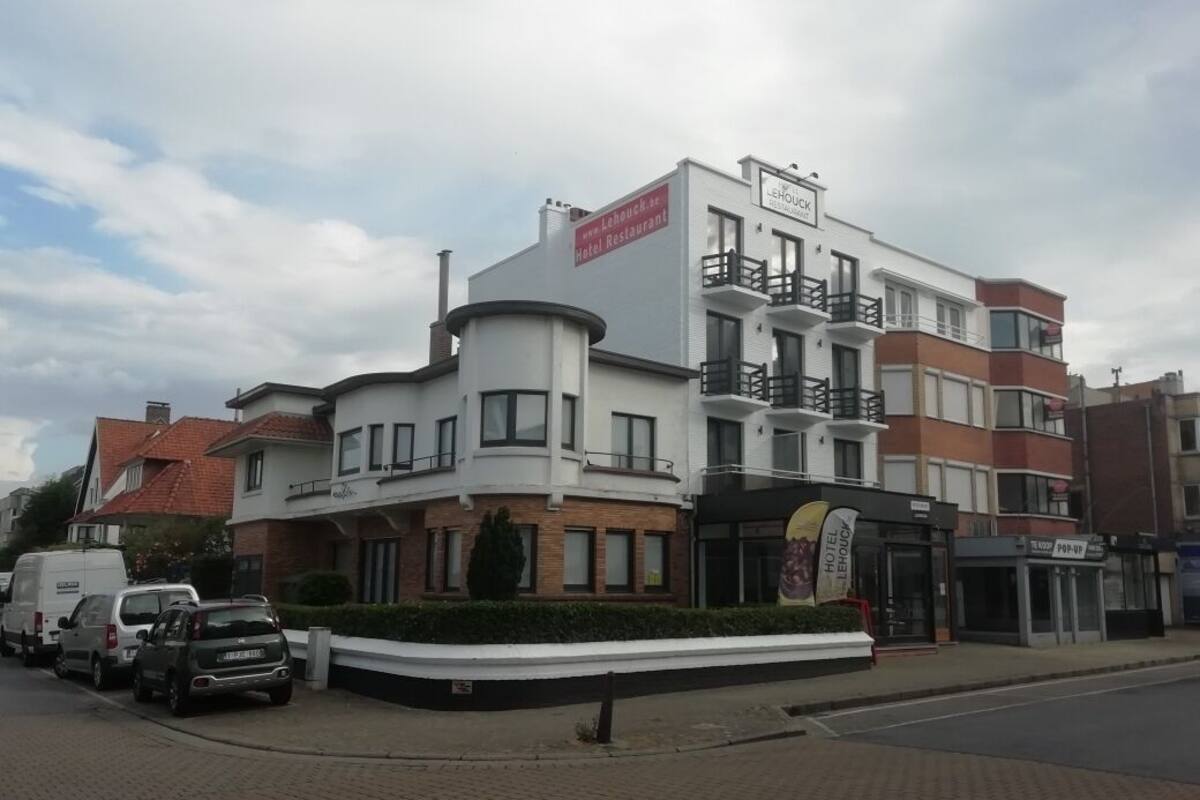Ein Hotel mit modernem Design, das durch einen markanten Eingangsbereich und ein Schild gekennzeichnet ist.