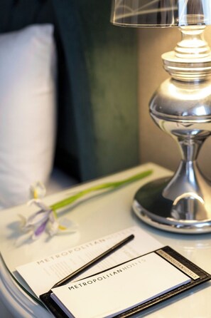 A hotel room with a bedside table, a lamp, a notepad, and a pen. - Metropolitan Hotels Taksim (Istanbul)
