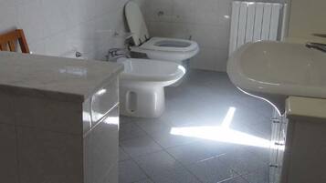 Ein Badezimmer mit Toilette, Bidet und Waschbecken.