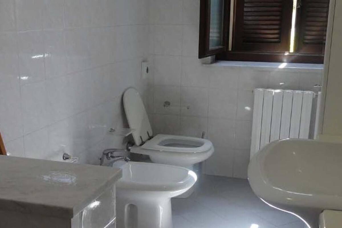A small, compact bathroom with a toilet, bidet, and sink.