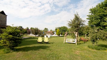 Relax in the serene outdoor space with a wooden swing set and Adirondack chairs.