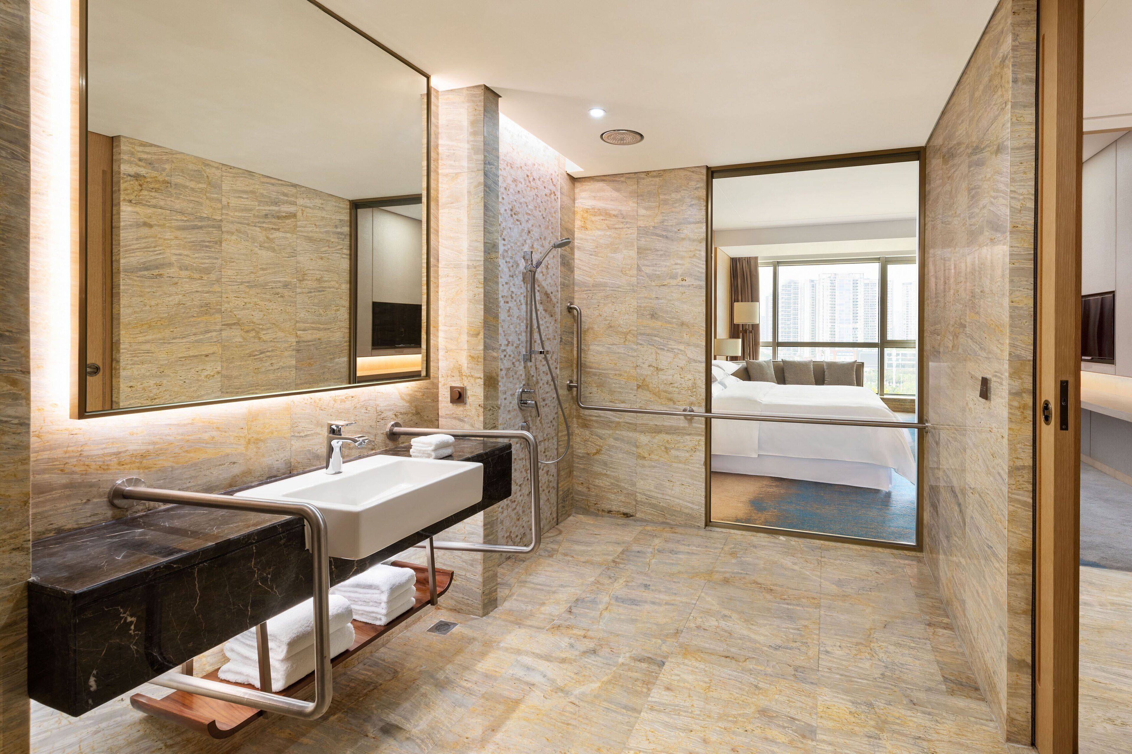 Een moderne badkamer met een marmeren vloer, een wastafel met een opbergmeubel, een douche en een grote spiegel.