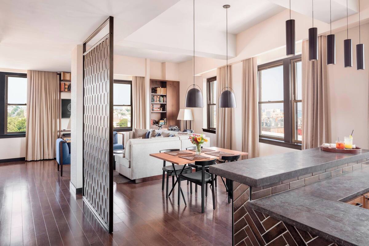Uma sala de estar moderna com área de jantar, um sofá, uma mesa de centro e uma estante.