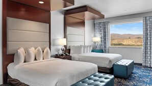 Une chambre d’hôtel avec deux lits, une grande fenêtre donnant sur les montagnes, un sol à motifs et un design moderne.