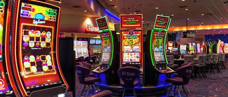 A casino floor with slot machines and gaming tables.