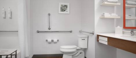 A modern bathroom with a toilet, shower, and sink.