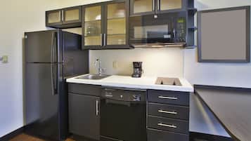 A modern kitchen with a refrigerator, dishwasher, microwave, and coffee maker.