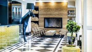 Un vestíbulo moderno con suelo de estampado geométrico, chimenea, estatua de caballo y estante para vinos.