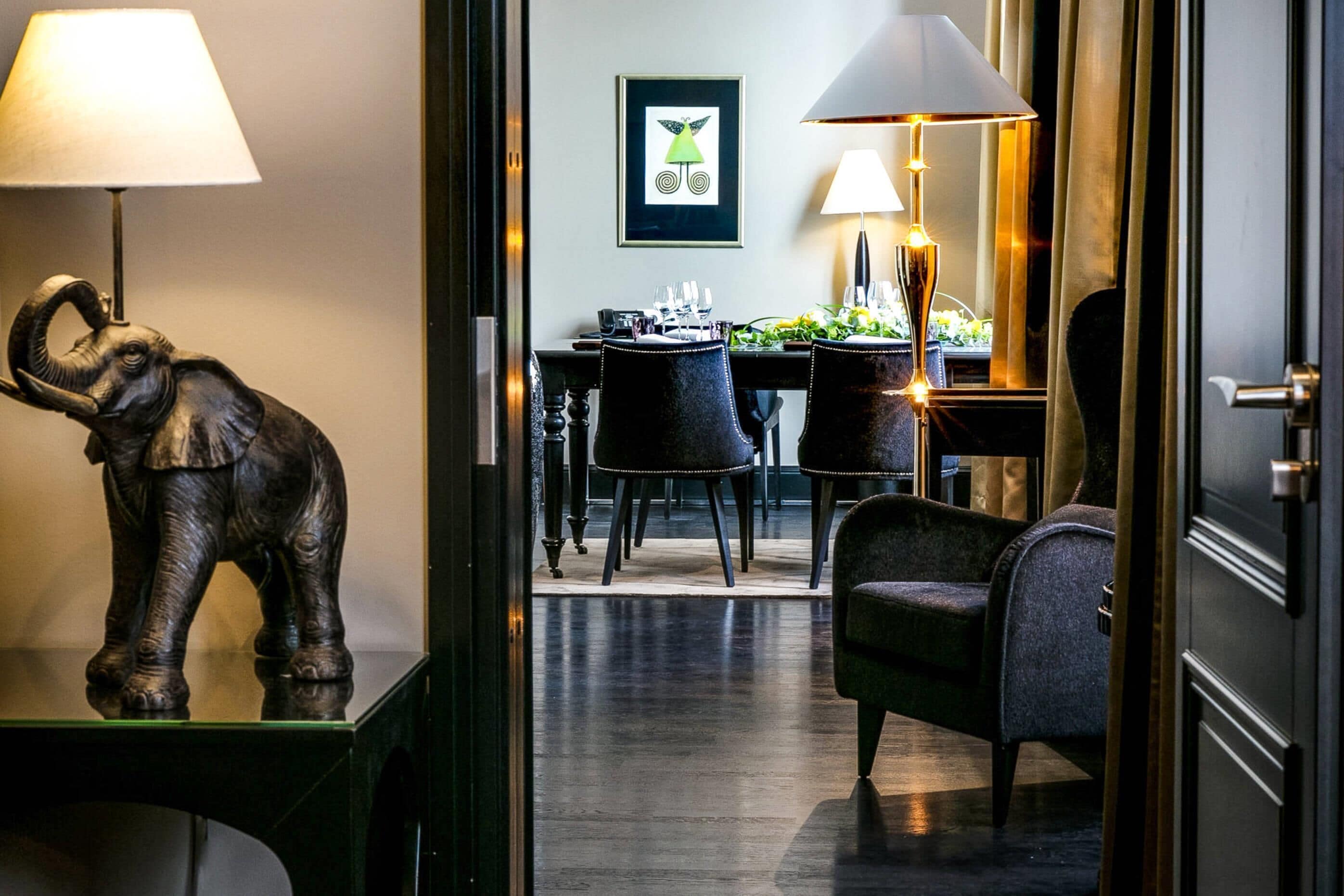Un hall d’hôtel comprenant un espace repas, une statue d’éléphant et une œuvre d’art encadrée accrochée au mur.