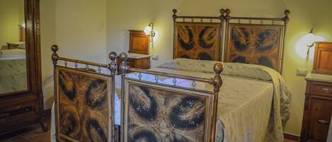 Ein Schlafzimmer mit Himmelbett, Holz-Kopfteil und Nachttischlampen.