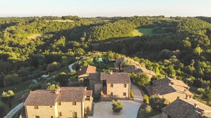 A rural estate with stone buildings, a swimming pool, and surrounding greenery. - PanElios Borgo Vacanze (Citta della Pieve)