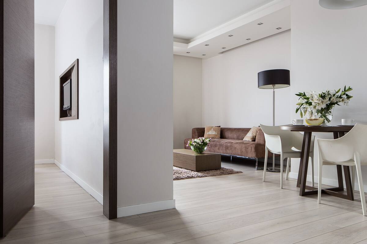 Un salon moderne avec un canapé, une table basse et un coin repas.