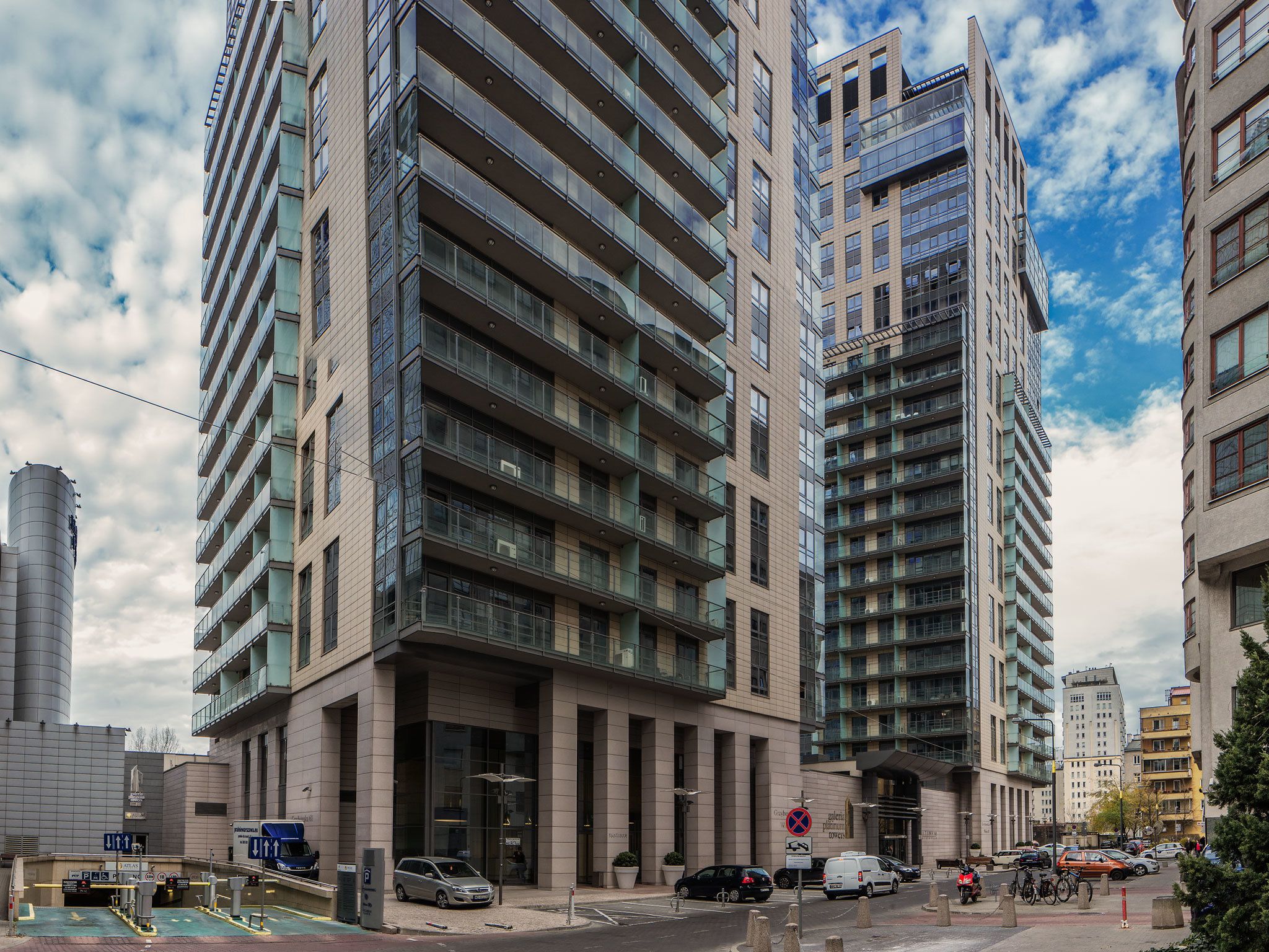 Un moderno edificio de gran altura con varios pisos, ventanas amplias y una entrada destacada.