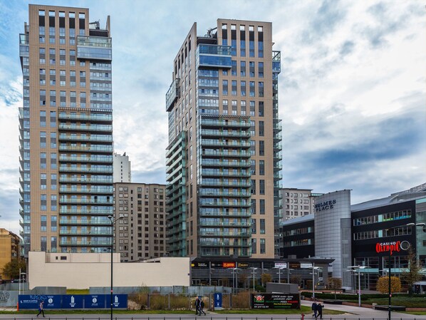 A modern high-rise building with multiple floors, large windows, and balconies. - Chopin Apartments Platinum Towers (Warsaw)