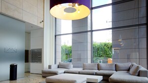 A spacious living area with a large sectional sofa, a coffee table, and a modern pendant light. - Chopin Apartments Platinum Towers (Warsaw)