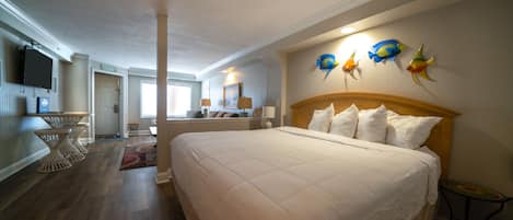 Ein Hotelzimmer mit einem großen Bett, einem Essbereich, einer Küche und einem Wohnzimmer.