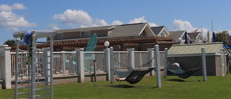 A playground with a hammock and a climbing structure.
