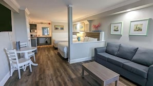 A compact living space with a kitchenette, a dining area, and a seating area with a sofa and a coffee table. - Islander Hotel & Resort (Emerald Isle)