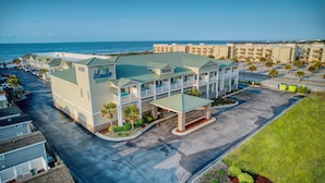 A hotel with a two-story structure, a covered entrance, and a view of the ocean. - Islander Hotel & Resort (Emerald Isle)