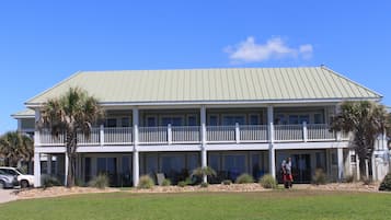 A two-story building with a flat roof and a balcony on the upper floor.